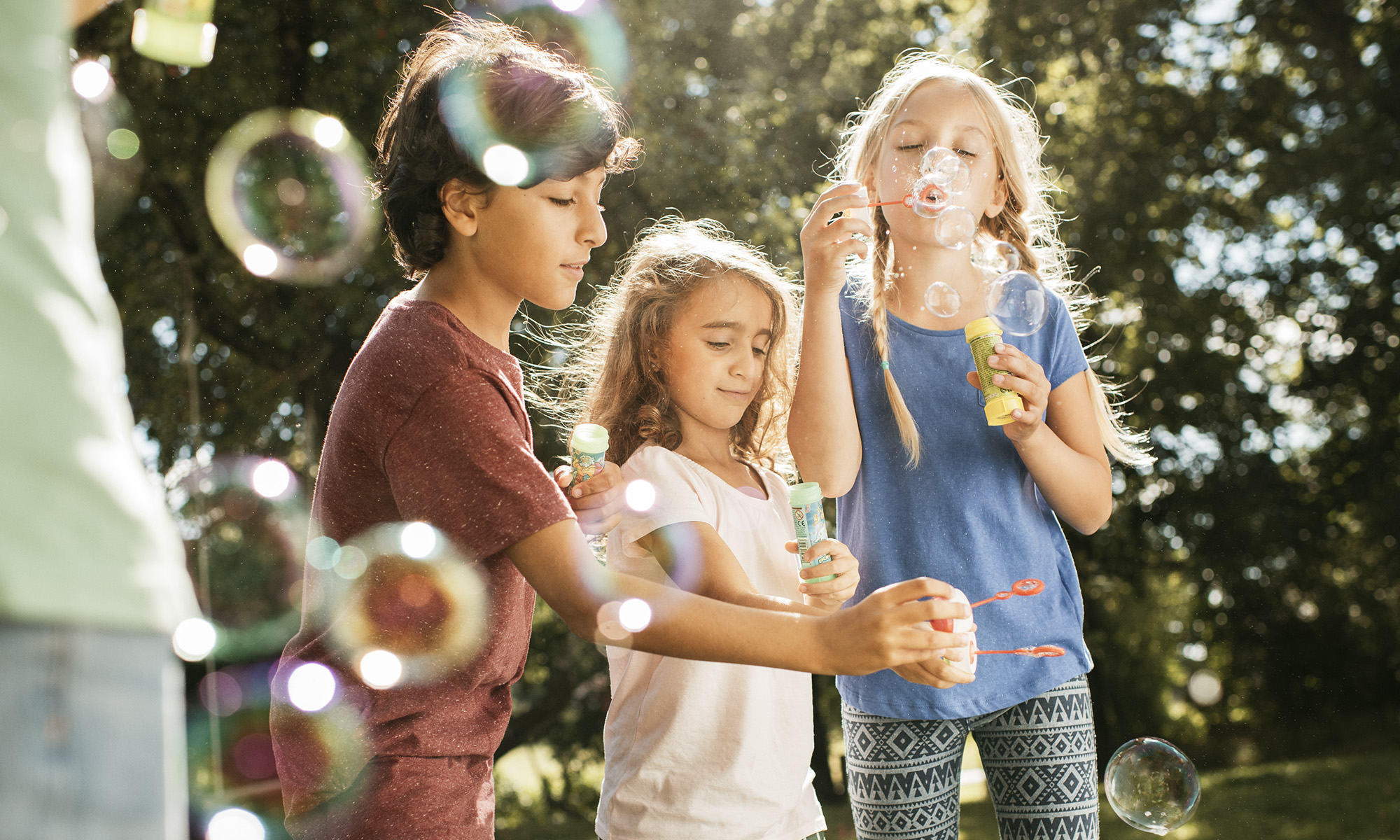 Three children blowing bubbles